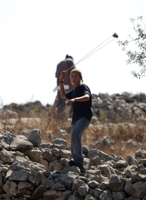 Israeli settlers hurl rocks at Palestinians, not seen, on the outskirts of Burin village, near the Jewish West Bank settlement of Yitzhar, near Nablus, on Monday.